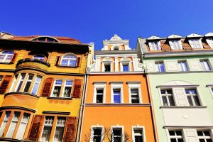 Bunte Hausfassaden in einer Stadt (Foto: freepik, wirestock) - Wohnungsnot Deutschland: hohe Mieten in Städten – Wirtschaft laufen Fachkräfte weg