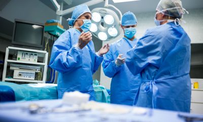 3 Ärzte in OP-Kleidung diskutieren in einem Operationssaal (Foto: freepik, peoplecreations)
