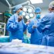 3 Ärzte in OP-Kleidung diskutieren in einem Operationssaal (Foto: freepik, peoplecreations)