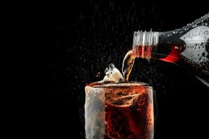 Glas wird aus Flasche mit Cola gefüllt (Foto: Freepik, lemonsoup14) - PepsiCo Quartalszahlen: Umsatz-Plus nach Dividenden-Anstieg? Übersicht und Prognose