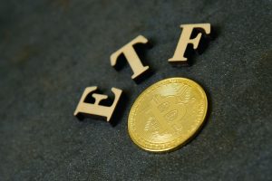 Goldene Bitcoin-Münze mit Schriftzug ETF (Foto: Freepik, plysuikvv) - Bitcoin ETF: jetzt kaufen – oder auf SEC-Entscheidung warten?