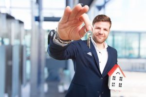 Immobilienmakler mit Haus-Modell und Schlüssel (Foto: Freepik, kues1) - Immobilien-Kauf 2024: Sinkende Bauzinsen größeres Angebot – Makler zuversichtlich