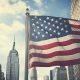 US-Flagge in einer Straße mit Wolkenkratzern (Foto: Freepik) - Fed Leitzins aktuell – Sitzung und Zinsentscheid nach schwachem BIP in den USA