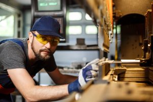 Arbeiter neben Maschine zur Metallbearbeitung - Ostdeutsche Maschinenbauer trotzen der Krise