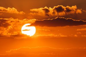 Untergehende Sonne, teilweise von Wolken bedeckt (Foto: Freepik, wirestock) - Klimawandel: Sonnenschirme im All sollen Erderwärmung stoppen