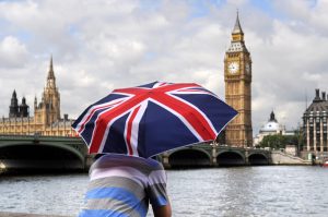 Blick über Themse auf Big Ben in London mit Union-Jack-Regenschirm - Geldpolitik Großbritannien: BOE Zinsentscheid aktuell