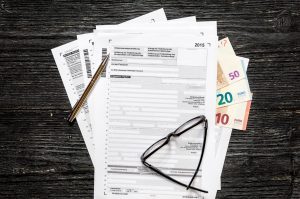 Steuerformular und Euroscheine auf einem Tisch - 30 Millionen Deutsche machen Online-Steuererklärung
