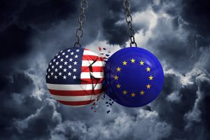Zwei Kugeln mit Flaggen der USA und der EU stoßen aufeinander vor Gewitter-Kulisse (Foto: freepik, inkdrop) - Grüne Industrie: Habeck in USA – bessert Biden Subventionen nach?