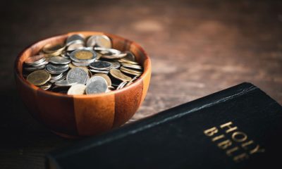 Schale mit Geldstücken, daneben eine Bibel (Foto: freepik, doidam10)