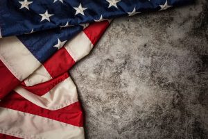 Flagge der USA vor graumelierter Mauer - Wirtschaft droht Rezession