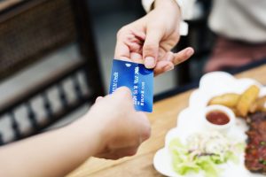 Per Kreditkarte im Restaurant zahlen (Freepik, rawpixel.com) - Amex Quartalszahlen: Reise-Geschäfte und Kredit-Risiken – Prognose und Überblick