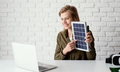 Frau an einem Schreibtisch mit einem Solarmodul in der Hand (Foto: freepik, freepik)