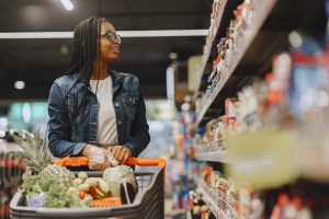 Frau vor Lebensmittelregal im Supermarkt (Foto: freepik, prostooleh) - Inflation: Kunden kaufen mehr Handelsmarken