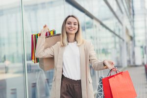 Frau mit Einkaufstaschen vor Schaufenster (Foto: freepik, ktvstosk) - Konsumklima 2023 – Kauflaune der Verbraucher bessert sich