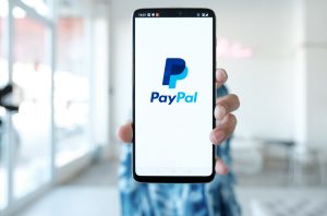 Hand hält Smarthone mit PayPal-Logo (Foto: freepik, mteerapat) - PayPal Quartalszahlen: nach Stellenabbau und Datenpanne – Prognose und Überblick