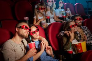 Menschen mit 3-D-Brillen und Popcorn im Kino (Symbolbild, Foto: freepik, fabrikasimf) - AMC Quartalszahlen: Meme-Aktie vor Reverse Split – Prognose und Übersicht