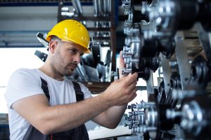 Industriearbeiter arbeitet an einer Produktionslinie in einer Fabrik - Deutsche Industrie ächzt unter Auftragsstau