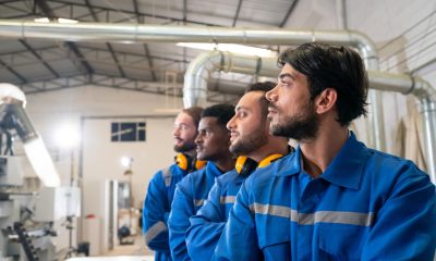 4 Arbeiter in blauen Overalls in einer Möbelfabrik (Foto: freepik, user6699736)