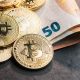 Kryptowährung Bitcoin auf Euro-Geldscheinen