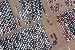 Luftaufnahme von parkplatz mit vielen hundert Neuwagen (Foto: freepik, tawatchai07) - Konjunktur: Deutsche Autobauer für 2023 optimistischer