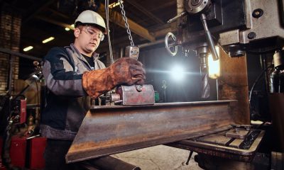 Arbeiter mit Schutzhelm an einer Maschine in einem metallverarbeitenden Betrieb (Foto: freepik, fxquadro)