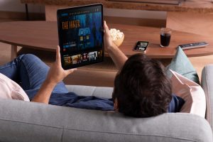 Mann streamt Film auf Tablet - US-Streamer kündigen gerne Amazon Prime