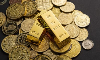 Goldmünzen und Goldbarren auf schwarzem Untergrund (Foto: freepik, wirestock)