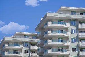 Weißes Mehrfamilienhaus mit Balkonen (Foto: freepik, mister_big) - Vonovia Bilanz 2022: Baukrise und Dividendensorge – Prognose und Übersicht