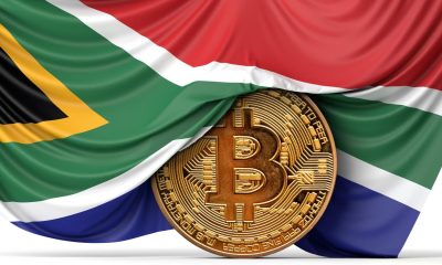 Flagge von Südafrika über einer Bitcoin Münze