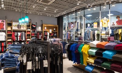 Verkaufsraum eines Bekleidungsgeschäfts mit Hemden und Jeans