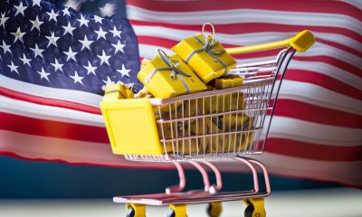 Einkaufwagen mit Geschenken vor Flagge der USA - Inflation aktuell (Foto: Freepik, mashalcryb)