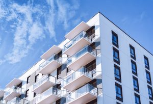 Fassade eines weißen, mehrgeschossigen Wohnhauses (Foto: freepik, roman_babakin) - Immobilienpreise 2023: Wohnungen in Großstädten deutlich billiger – jetzt kaufen?