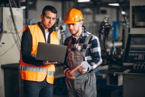 Zwei Industriearbeiter in Fabrik mit Lapotop (Foto: freepik, senivpetro) - Auftragsplus für Industrie und Umsatzrekord für Dienstleister